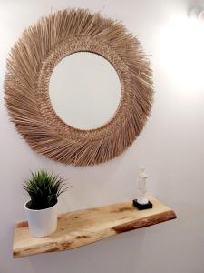 un espejo en una pared con una planta en un estante en Roque's House, en Telde
