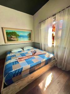 a bedroom with a bed with a quilt on it at Suíte Explorer in Praia Grande
