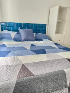 1 dormitorio con 2 camas y edredón azul y blanco en Tiny house Santa Ana en Santa Ana