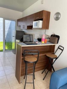 a kitchen with a desk with a laptop and two chairs at Tiny house Santa Ana in Santa Ana