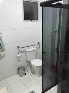 a bathroom with a toilet and a glass shower at Condomínio no coração de São Paulo in São Paulo