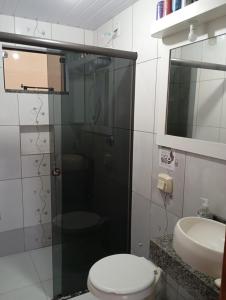 een badkamer met een douche, een toilet en een wastafel bij Pousada Hawaii in Barra Velha