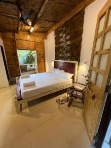 a bedroom with a large bed and a window at Jeet Hostel & Rooms in Canacona