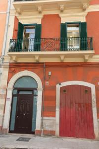 a red building with two doors and a balcony at Maison Sara in Bari
