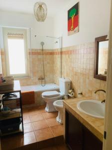uma casa de banho com um WC, um lavatório e uma banheira em Casa Franca a Marzamemi em Marzamemi