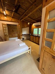 a bedroom with a bed in a room with wooden ceilings at Jeet Hostel & Rooms in Canacona