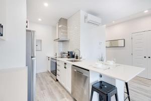 a white kitchen with a sink and a refrigerator at M11 Neat & Spacious 1BR in Heart of Plateau MTL in Montréal