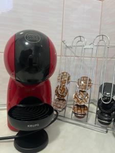 a red coffee maker next to a rack of cookies at Apartman Lena in Belgrade +3 photos