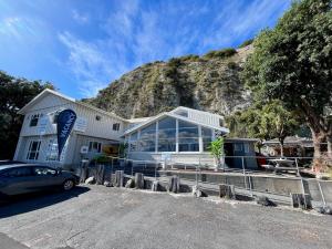 a white building with a mountain in the background at Kaikoura Seaside lodge in Kaikoura