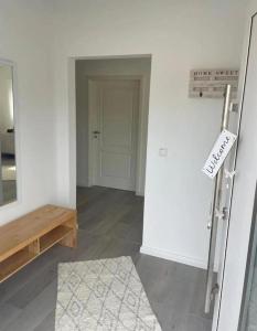ein weißes Zimmer mit einer Tür und einem Schild an der Wand in der Unterkunft HOME OF VACATION - Landhausstil zum Wohlfühlen - FREE WIFI & NETFLIX in Adelheidsdorf
