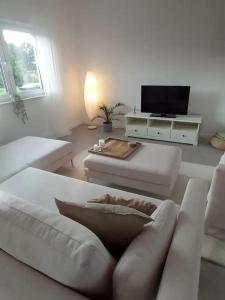ein Wohnzimmer mit einem Sofa und einem TV in der Unterkunft HOME OF VACATION - Landhausstil zum Wohlfühlen - FREE WIFI & NETFLIX in Adelheidsdorf