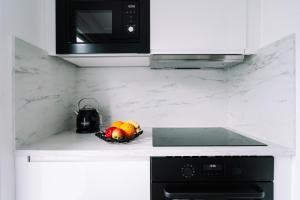 a kitchen counter with a bowl of fruit and a microwave at Green Flat Düsseldorf 2.0 in Düsseldorf
