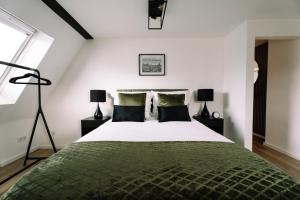 a bedroom with a large green bed with two lamps at Green Flat Düsseldorf 2.0 in Düsseldorf