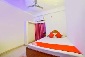 1 dormitorio con 1 cama de color naranja y blanco en OYO Flagship Mamta Hotel en Hājīpur