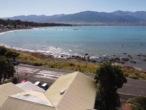 - une vue sur la plage avec un bâtiment et l'eau dans l'établissement Kaikoura Seaside lodge, à Kaikoura