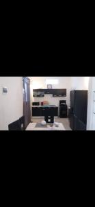una gran cocina con electrodomésticos negros en una habitación en Cosy Home Sweet Home, en Moroni