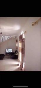 una persona in piedi in un soggiorno con divano di Cosy Home Sweet Home a Moroni