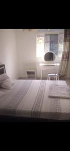 1 dormitorio con cama, mesa y ventana en Cosy Home Sweet Home, en Moroni