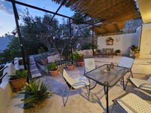 a patio with chairs and a table and some plants at Papas Apartments in Moírai
