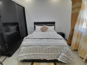 - une chambre avec un lit et une couette noire et blanche dans l'établissement RuffsOver Homes, à Baatsona