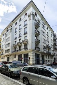 a large white building with cars parked in front of it at N16 Deluxe Apartment in Budapest