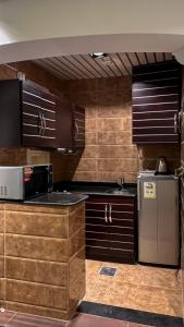 a kitchen with wooden cabinets and a stainless steel refrigerator at أبها مارينا فيلا in Abha