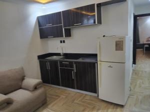 a kitchen with a white refrigerator and a couch at Jeddah Grand Beach in Jeddah