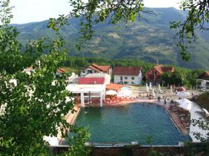 a swimming pool in a resort with mountains in the background at Guest house Pribojska Banja in Pribojska Banja