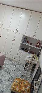a kitchen with white cabinets and a table in a room at Flat rent berat in Berat