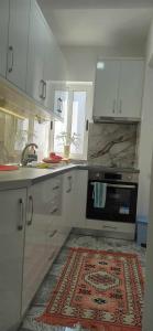 a kitchen with white cabinets and a rug on the floor at Flat rent berat in Berat