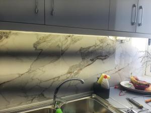 a kitchen with a sink and a marble counter top at Flat rent berat in Berat