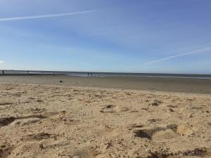 uma praia vazia com pegadas na areia em Hotelapartment Meerlust em Cuxhaven