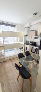 a kitchen with a glass table and a chair at Chapel studios in Ilford