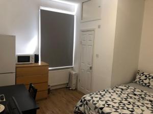 a bedroom with a bed and a dresser and a window at London x DM Weekly x Monthly Discounts x W13 in Greenford