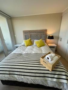 - une chambre avec un grand lit et des oreillers jaunes dans l'établissement Acogedor Departamento estudio en centro de Chillán, à Chillán