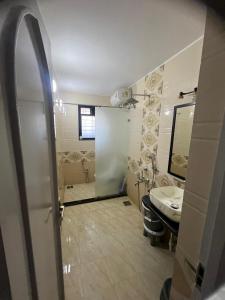ein Badezimmer mit einem Waschbecken, einem WC und einem Spiegel in der Unterkunft Luxurious 2Bhk Fully Furnished apartment in Pune