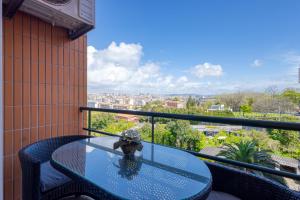 a glass table on a balcony with a view at Candal Douro in Vila Nova de Gaia