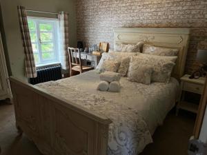 a bedroom with a large bed with a teddy bear on it at The Bridge House Restaurant and Hotel in Alton