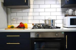 a kitchen with a stove and a microwave at Falkirk City Centre Stylish Two-Bedrooms Apartment in Falkirk