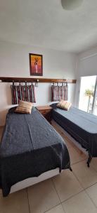 1 Schlafzimmer mit 2 Betten und einem Fenster in der Unterkunft Departamento Fragueiro 2414 terraza exclusiva in Cordoba