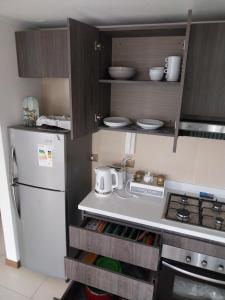 a kitchen with a white refrigerator and a stove at Azul 1 in Iquique