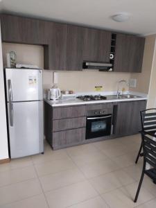 a kitchen with a white refrigerator and a sink at Azul 1 in Iquique
