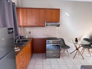 cocina con armarios de madera y horno de acero inoxidable en Golden View, en Agia Pelagia