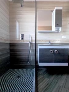 bagno con doccia, lavandino e specchio di Left and Right Hostel a Tirana