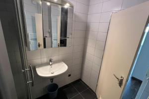 a white bathroom with a sink and a mirror at Apartment in Hannover! contactless check-in in Hannover