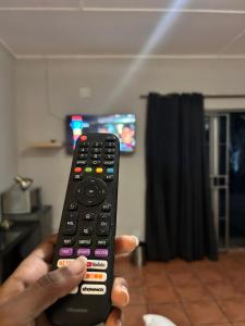 a person holding a remote control in a room at Bothabelo Bed and Breakfast in Phalaborwa