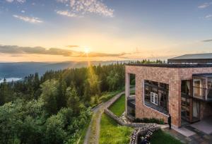 una casa en una colina con la puesta de sol en el fondo en Soria Moria Hotell, en Oslo