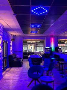 a room with purple lights and ping pong tables at 100 Pipers Hotel in Blackpool