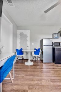 a kitchen with a table and two blue chairs at Pet friendly Studio with Private Yard in Orlando