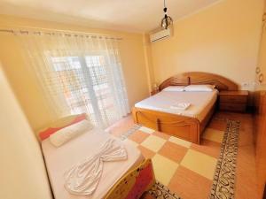 een kleine kamer met 2 bedden en een raam bij N&E Apartment 1 in Durres, Beach. in Durrës